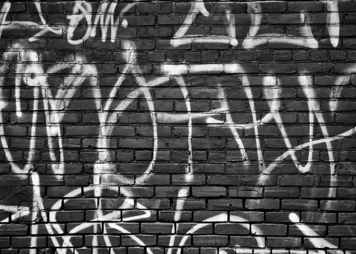 Weißes Graffiti an einer schwarzen Mauer
